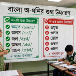শিক্ষক ব্ল্যাকবোর্ডে 'অ' দিয়ে শুরু শব্দের উচ্চারণরীতি শেখাচ্ছেন